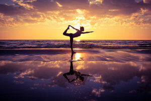 Gymnast posing in beach with sunset