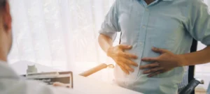 Man holding his belly (infront of the Doctor)