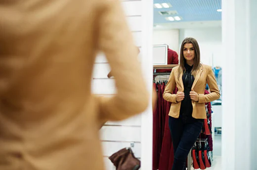 Girl fitting in clothes in front of a mirror