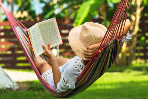 A girl in a hammock while reading